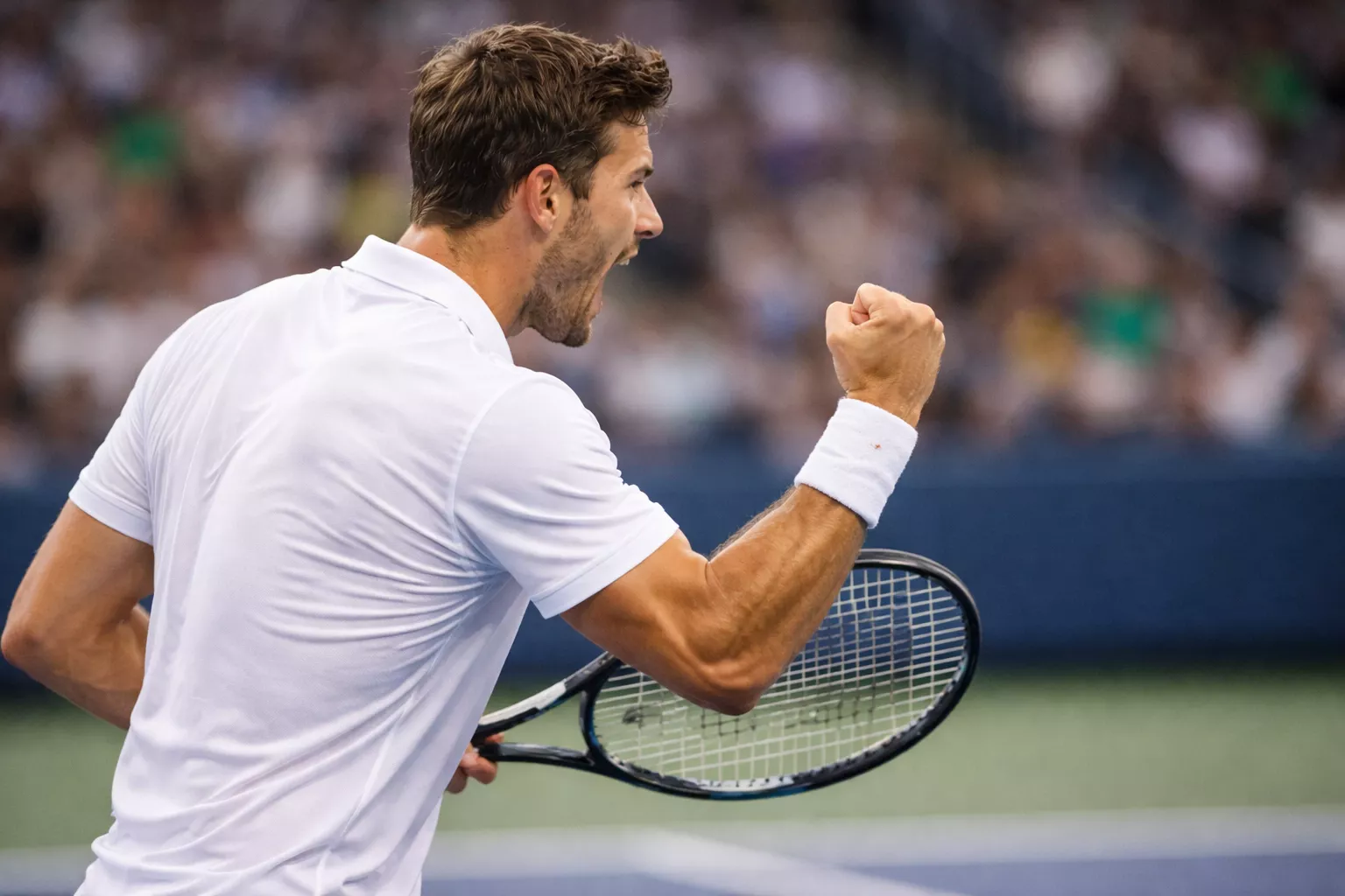 Tenista celebrando punto ganador con gesto de victoria